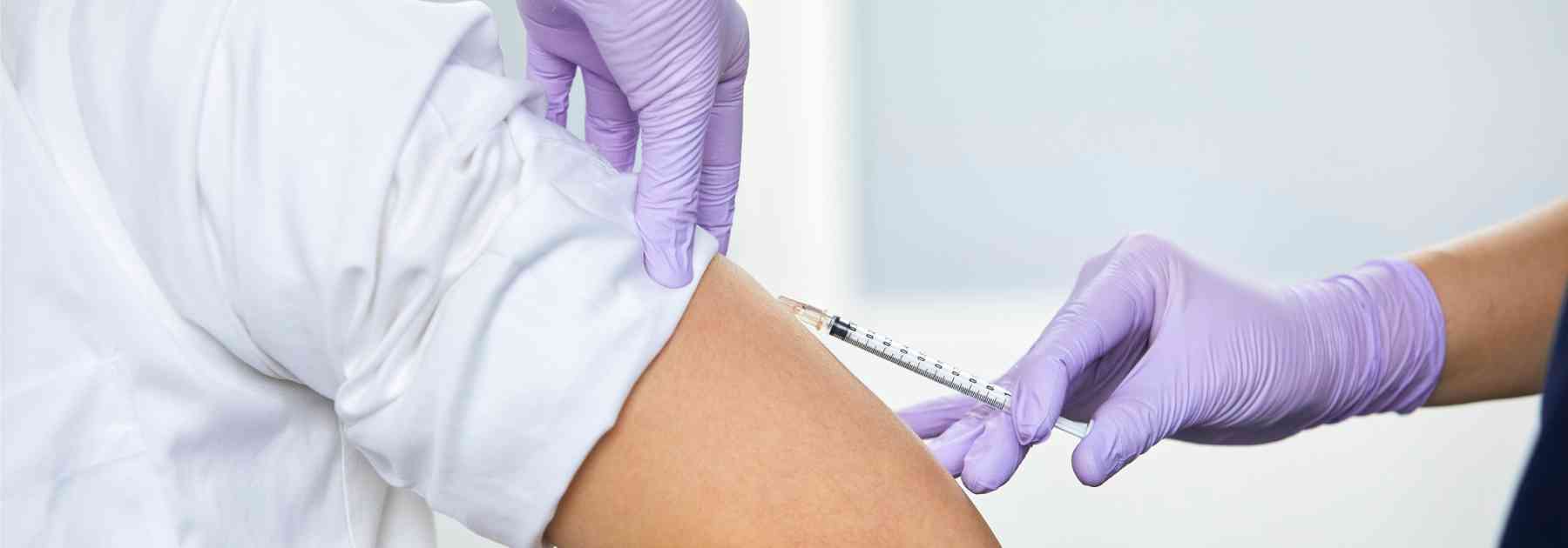 patient in white shirt receiving vaccine in arm