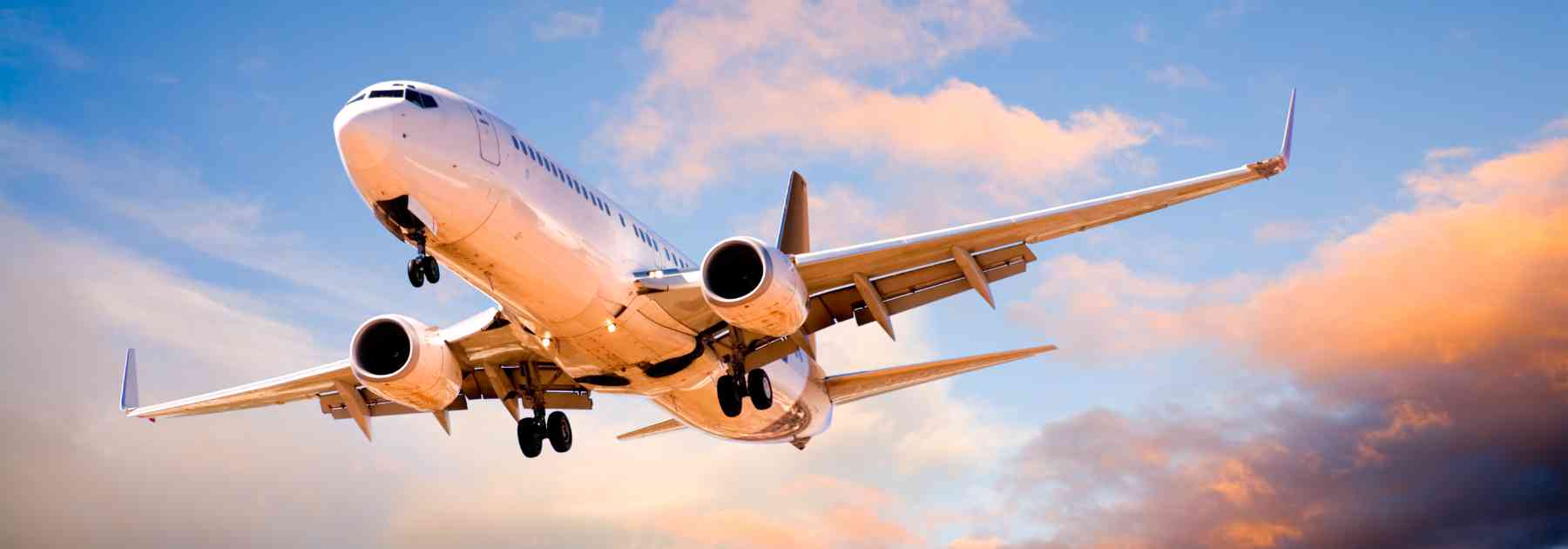 plane flying in sunset sky