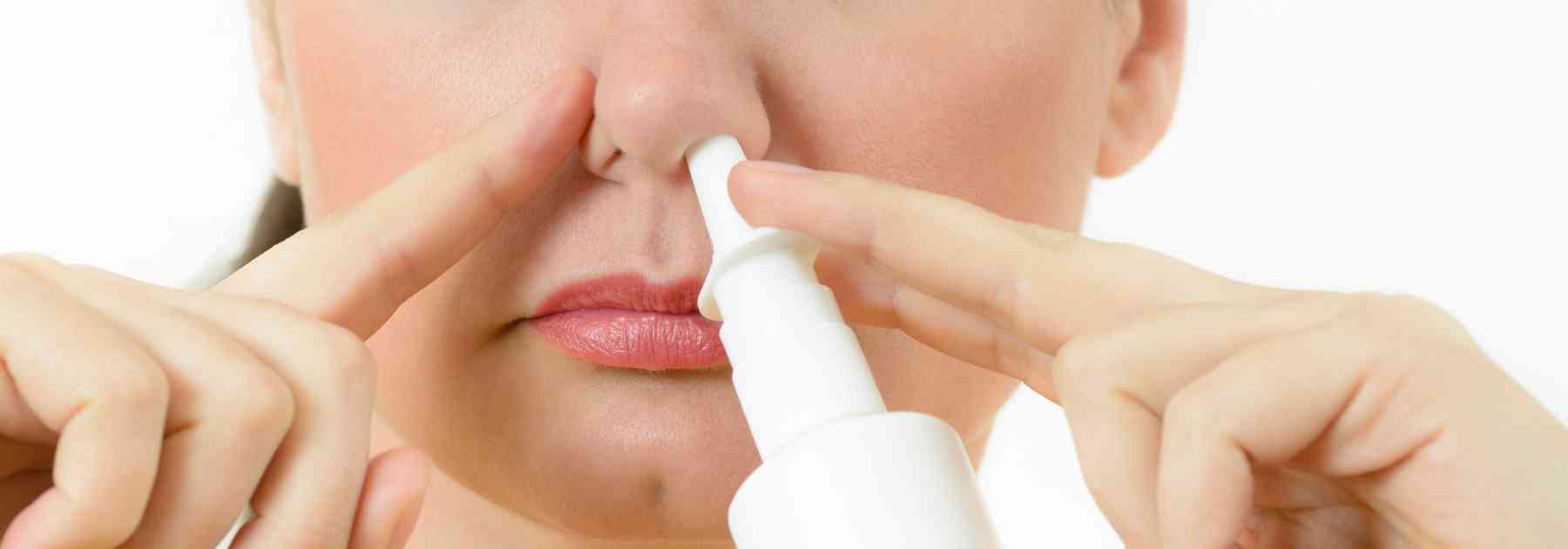 close-up of woman using nasal spray