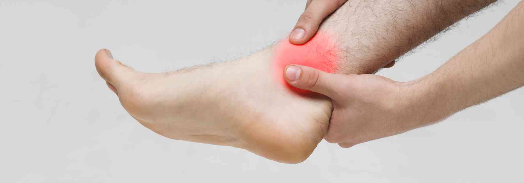 person holding their sprained ankle