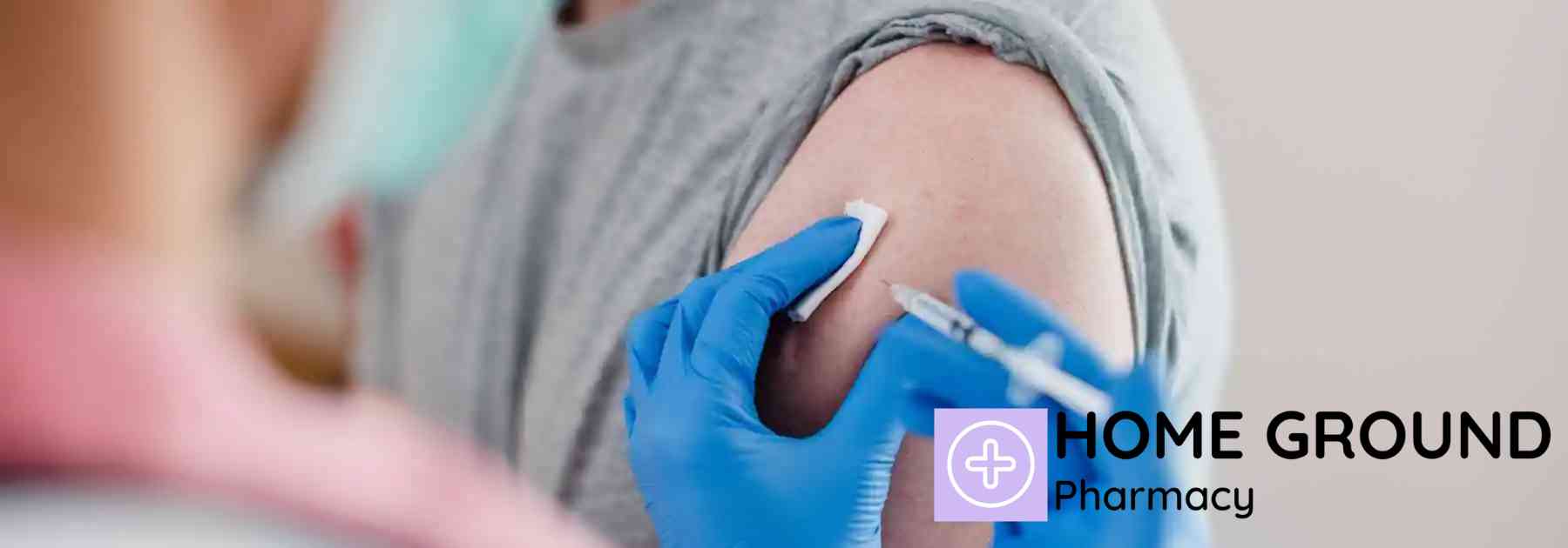 male patient in grey shirt receiving vaccine in arm