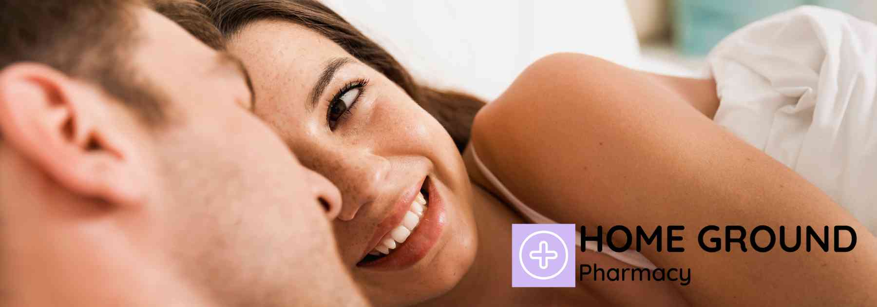 young woman smiling at her male partner in bed