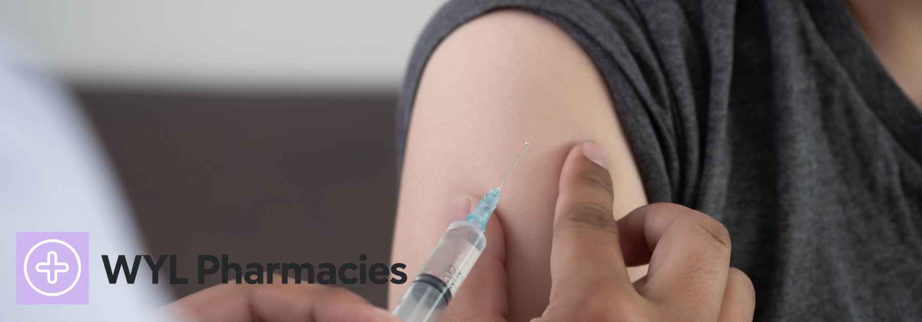 person in grey shirt receiving vaccine