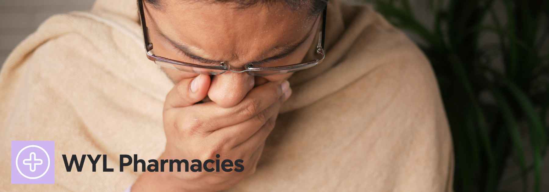 man wearing glasses and blanket coughing