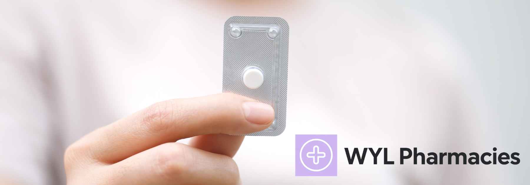 close-up of woman holding contraceptive pill