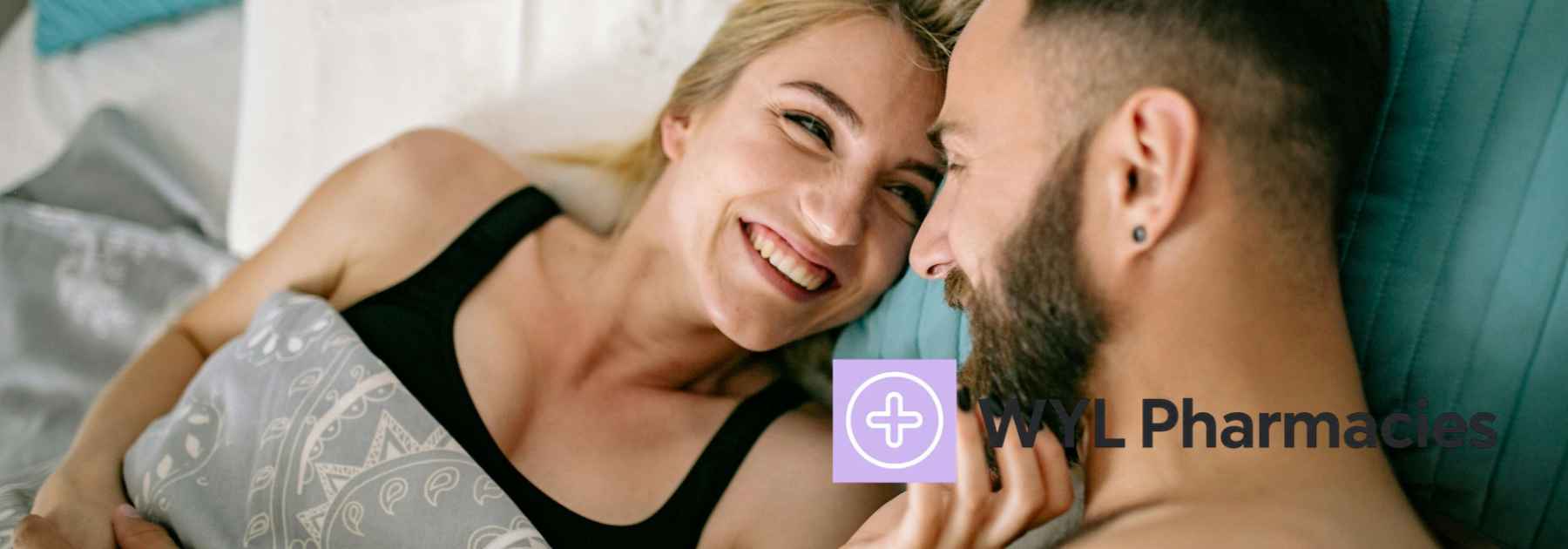 couple in bed smiling at each other